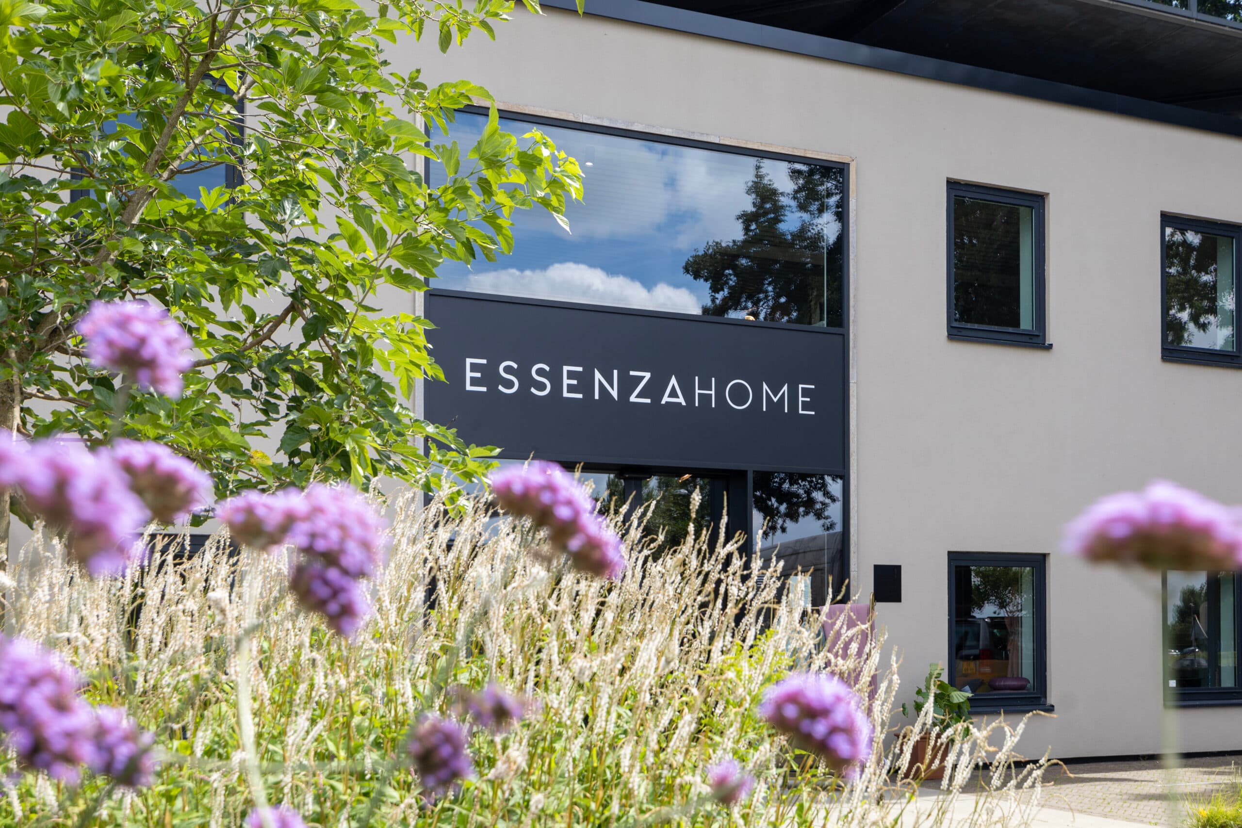 Bloemen op de voorgrond met het Essenza Home-logo op de gevel in Bunnik